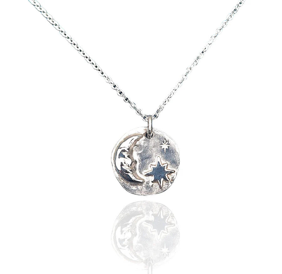 The Pale Raven "A Sailor's Dream Silver Necklace" features a silver crescent moon pendant with engraved celestial navigation designs and a star-shaped cutout, handmade in Dublin and shown on a white background with a soft reflection.