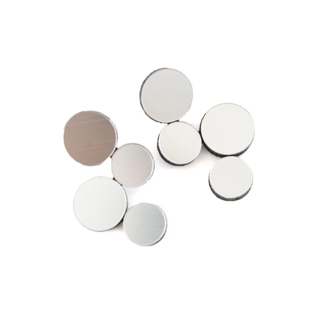 Abstraction Silver Earrings by Iskin Sisters, a set of small, round, flat metal discs reminiscent of geometric earrings, are arranged randomly on a white background.
