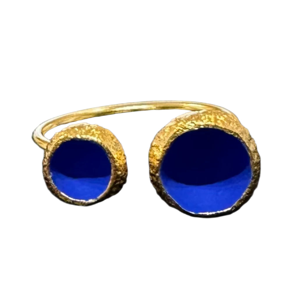 Gold plated ring with circular ends with cobalt blue interiors.