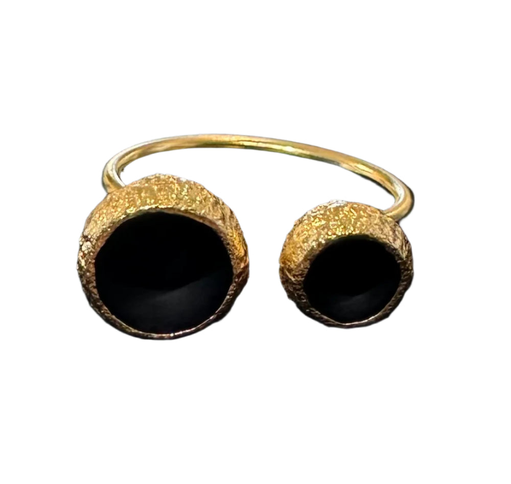 Gold plated ring with circular dome shape at each end with matt black interior.