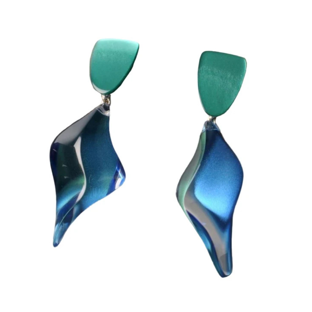 A pair of sculptural drop earrings featuring a rounded teal top section and a flowing, translucent blue and teal wave-shaped drop below, set against a plain white background.