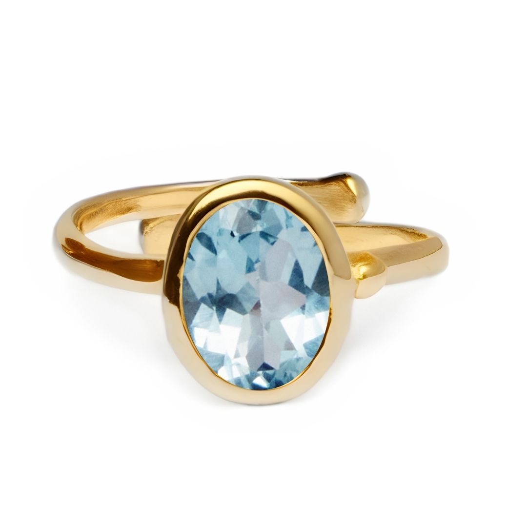 The Adjustable Dream Ring by Gallardo & Blaine Designs features an oval-shaped blue gemstone in a sleek, minimalist gold band, accentuating the large stone against a plain white background.