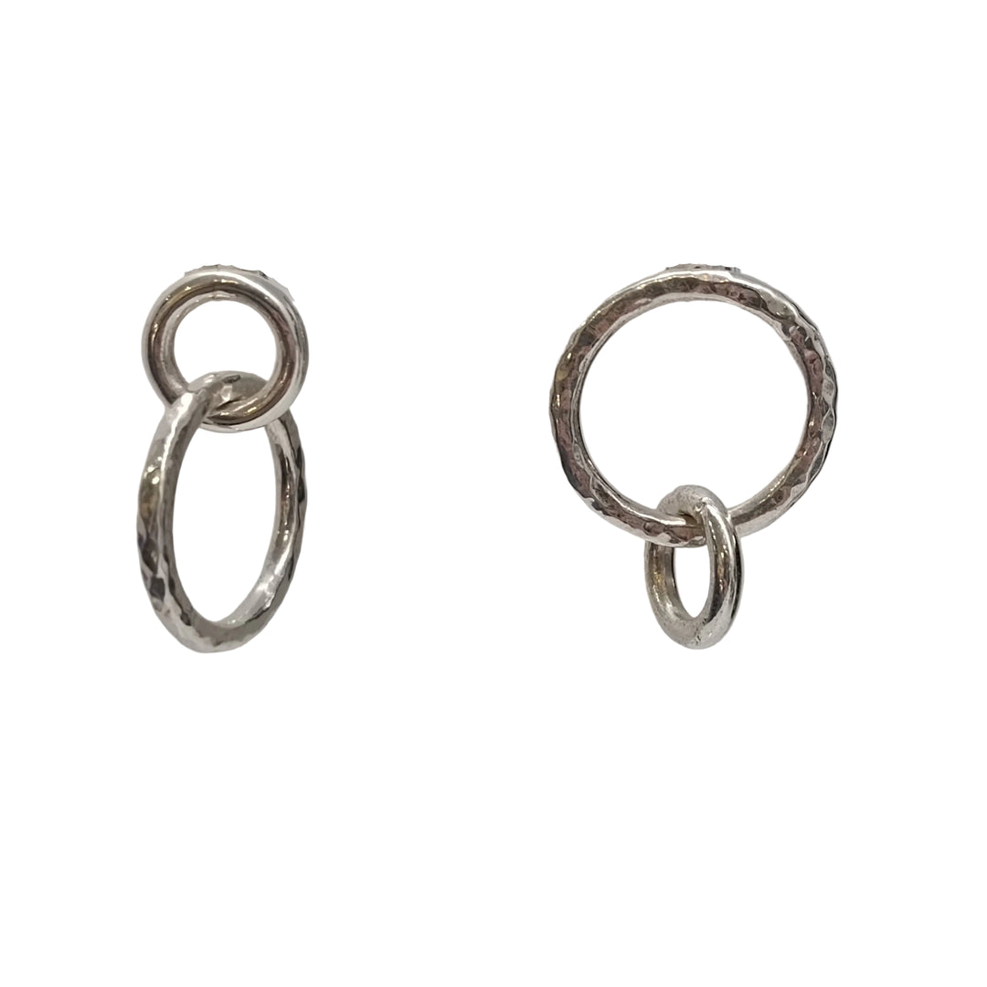 The Asymmetrical Chunky Silver Circle Earrings by K.And feature two pairs of interlocking silver rings—each with a smaller and a larger textured ring—displayed against a plain white background.