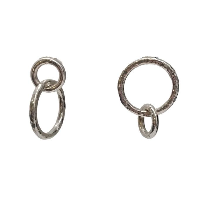 The Asymmetrical Chunky Silver Circle Earrings by K.And feature two pairs of interlocking silver rings—each with a smaller and a larger textured ring—displayed against a plain white background.