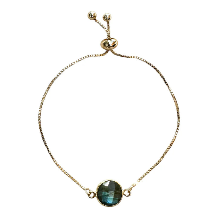 Introducing the Aurora Single Drop Bracelet by Aria V—a gold plated bracelet handmade in Dublin, featuring a round, iridescent labradorite gemstone at its center and finished with sliding bead clasps for easy size adjustment.