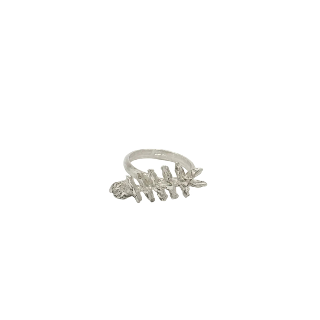 The Baraka Ring by Soufana Attia is a silver ring inspired by a fish skeleton, symbolizing protection and Baraka, shown upright on a simple white background.