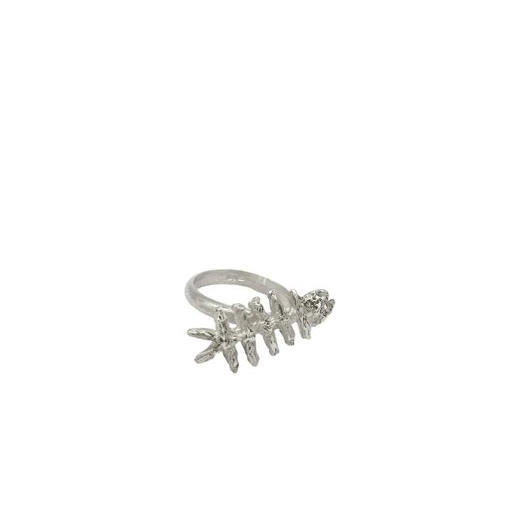 The Baraka Ring by Soufana Attia is a silver ring inspired by Arab symbols of protection and Baraka, designed to resemble a fish skeleton and shown on a plain white background.