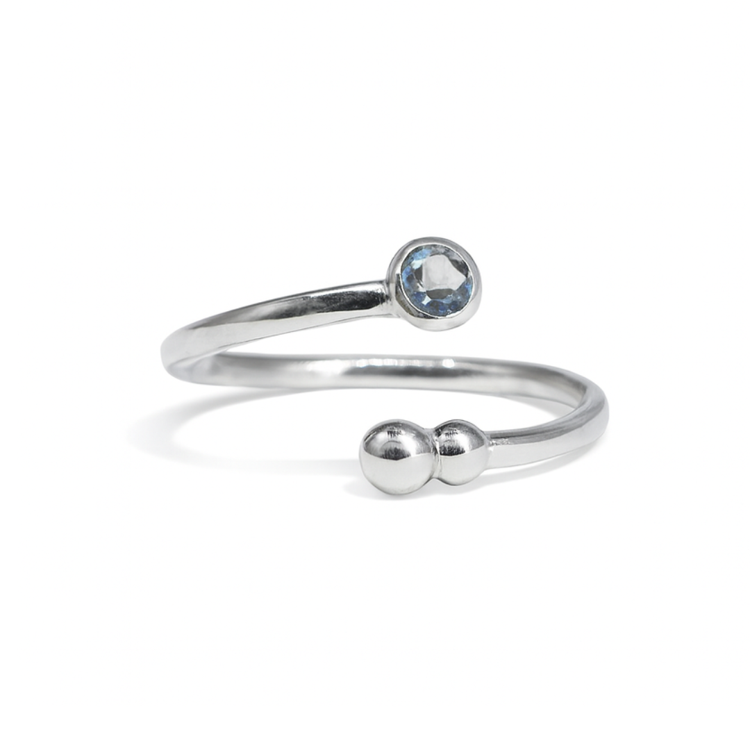 The Bauble & Stone Ring by Watermelon tropical is a minimalist gold-plated sterling silver ring, showcasing a round blue quartz stone on one end and two small silver beads on the other, displayed against a white background.