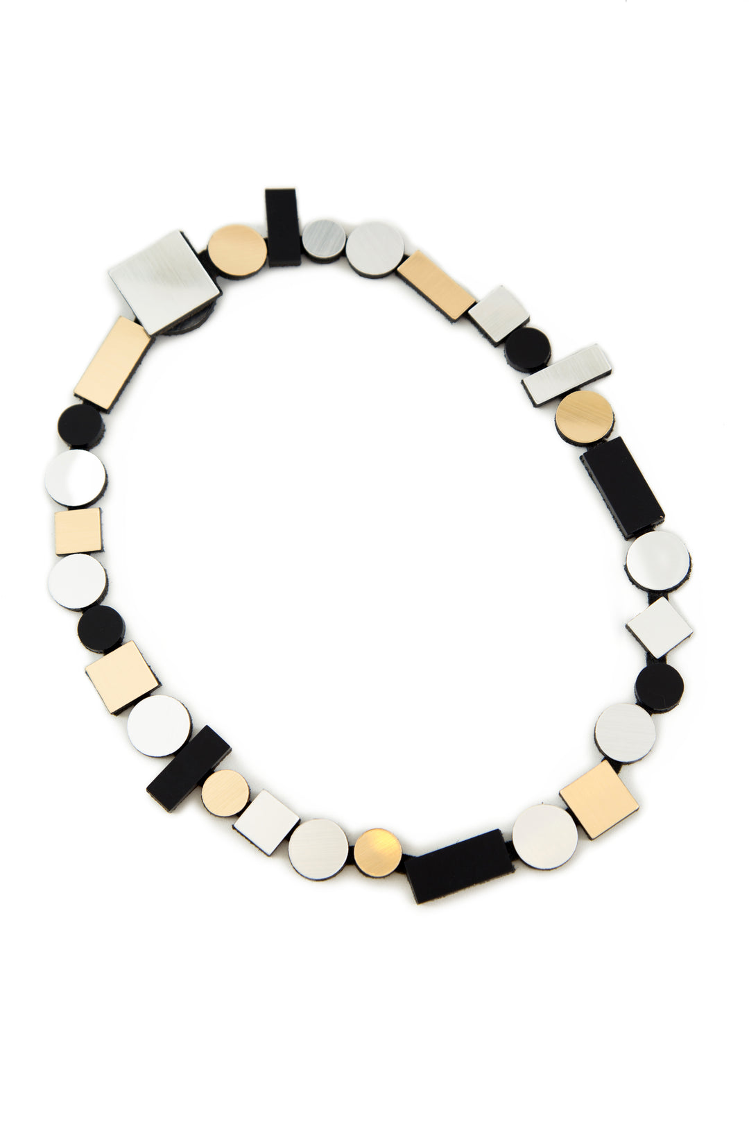 Presenting the Bauhaus Silver, Black & Gold Necklace from Iskin Sisters, this modern statement piece showcases an assortment of geometric shapes such as circles, rectangles, and squares in black, silver, and gold tones. The design links these shapes together in a continuous chain to create a contemporary and minimalist style.