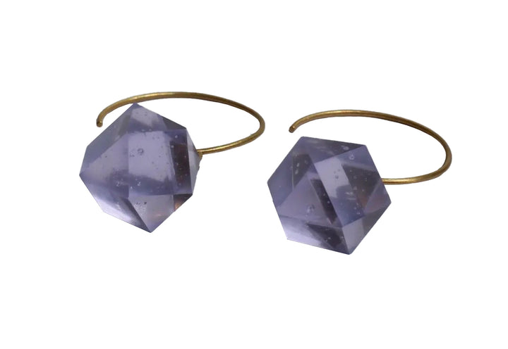 The Beira by Irene Reyes GEO Round Hook Earrings showcase two gold-colored hoops adorned with angular faceted translucent gray bullseye glass crystals, each featuring multiple reflective surfaces for an elegant touch.
