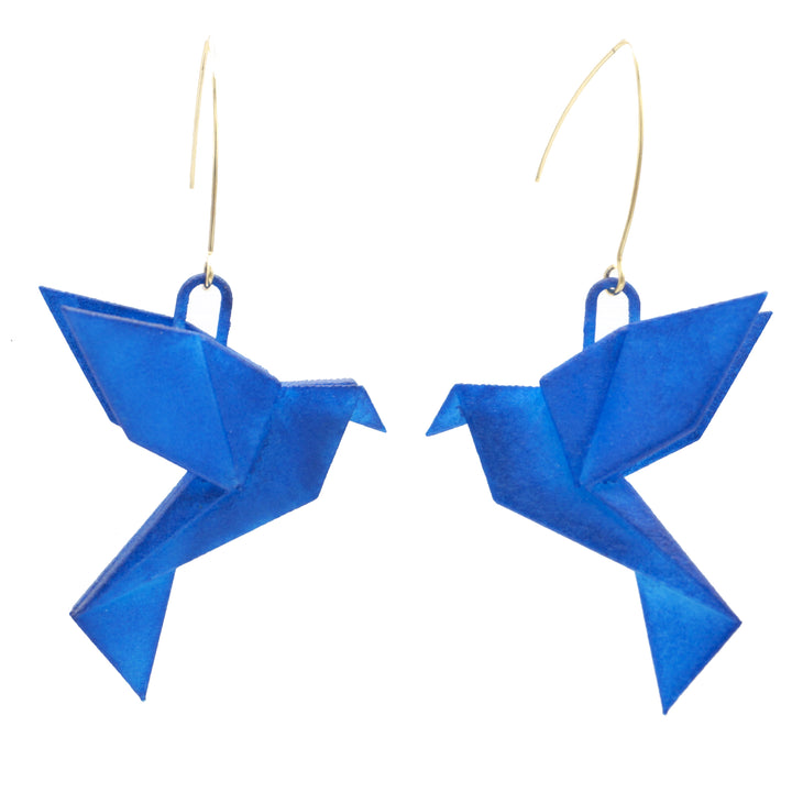 A pair of delicate, blue Origami Bird Blue Earrings by Tochu-De hang from thin, gold hooks. The birds are crafted from folded paper, with intricate wing and tail details, facing each other. Set against a plain white backdrop, these exquisite pieces of 3D printed nylon jewellery highlight the vibrant blue color of the birds.