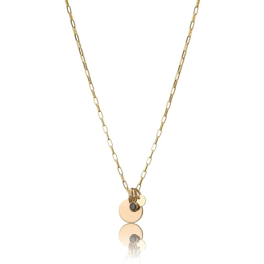 Gold necklace with circular pendants including black cubic zirconia on a white background.
