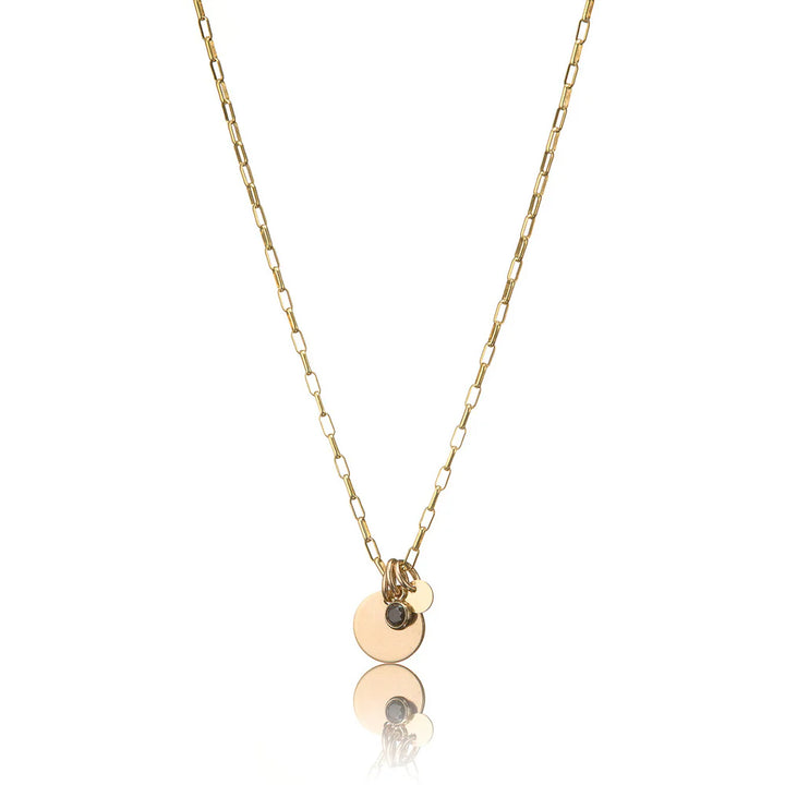 Gold necklace with circular pendants including black cubic zirconia on a white background.