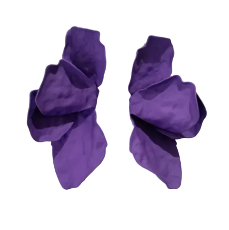 Two sculpted, crumpled, petal-like forms in vibrant purple rest on a textured surface—Bougainvillea Earrings in various colours by Kybalion Jewellery are a striking handcrafted statement.
