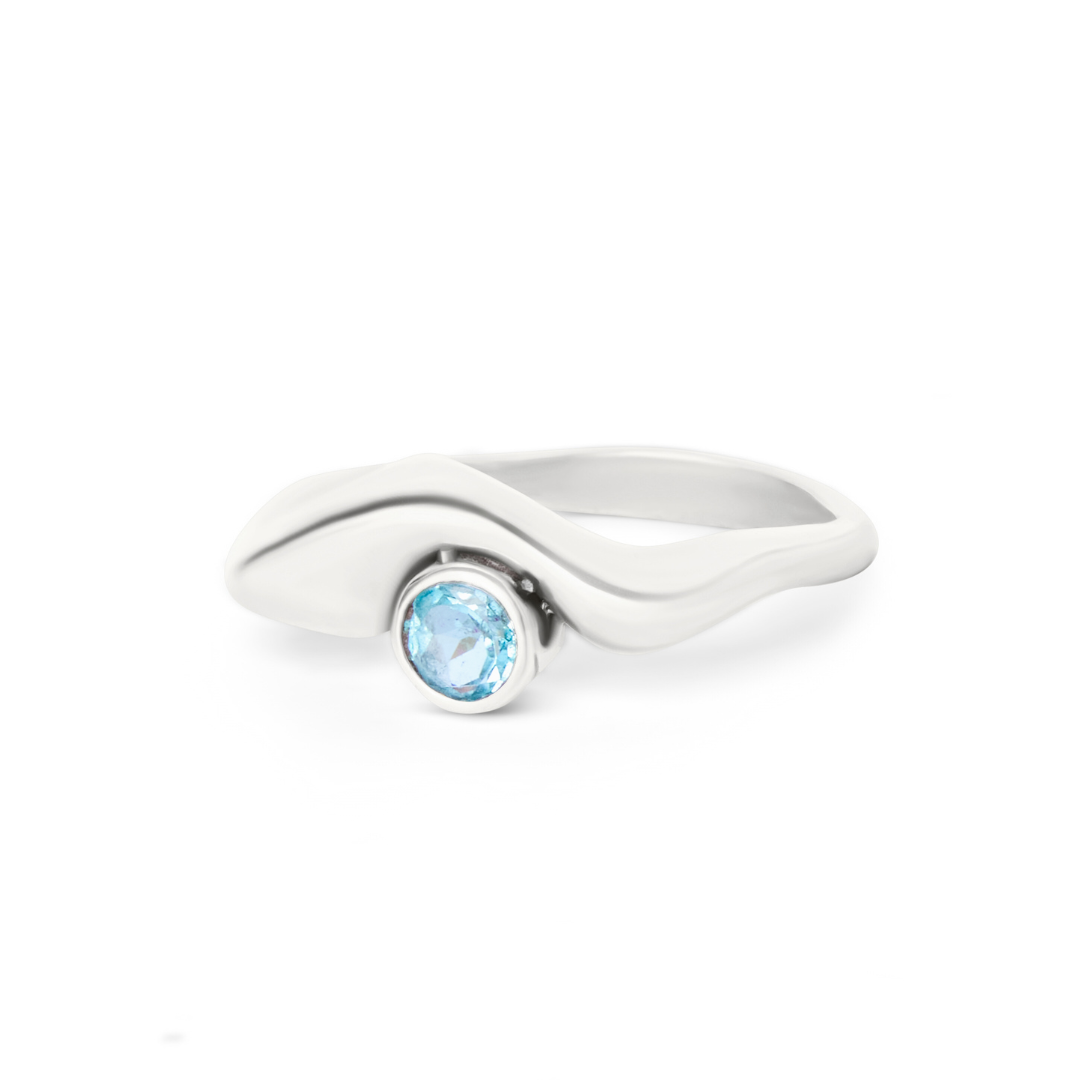 The Bough Ring by Madeleine Sculptural Jewellery features a modern wavy silver band with a round blue gemstone at the center. Handcrafted, this sleek piece highlights contemporary style and the stone's vibrant color.