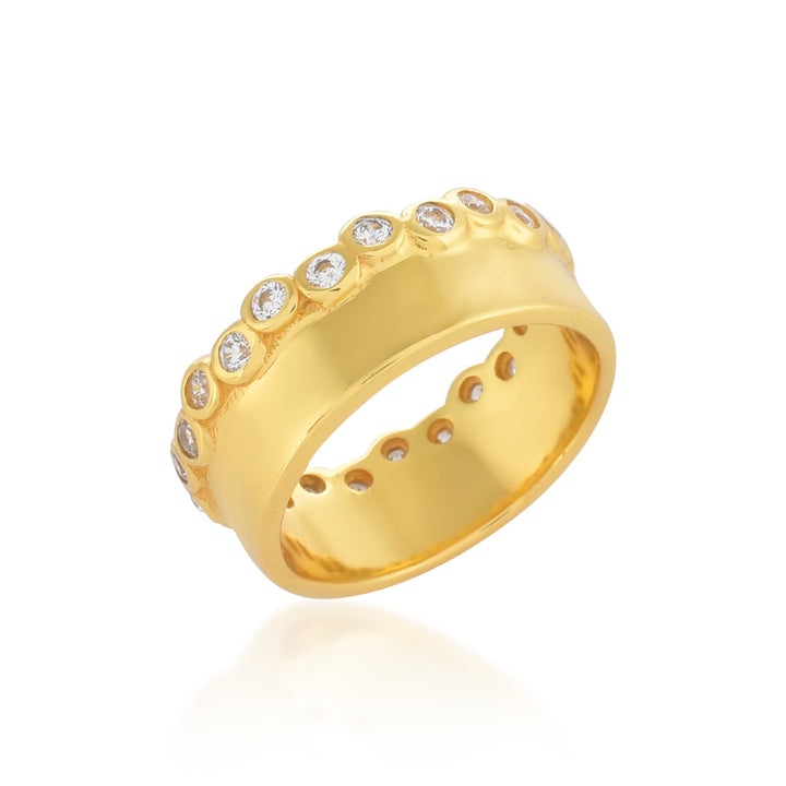 A luxurious Clarence Ring by Shyla adorned with multiple round diamonds set in a row around the band. The chunky gold ring features a polished, shiny finish with intricate detailing, giving it an elegant and sophisticated appearance.