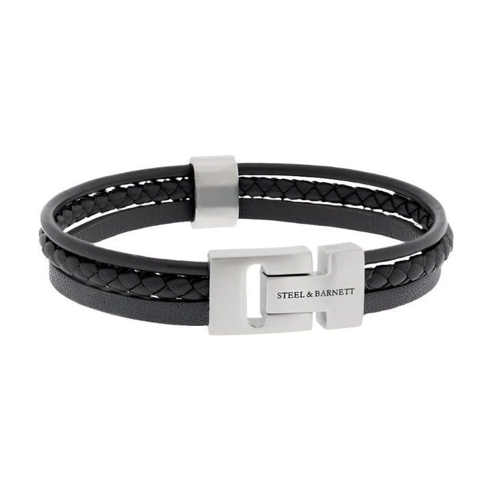 The Cole - Black bracelet by Steel and Barnett combines braided and smooth textures of black genuine leather, highlighted by a stainless steel clasp engraved with "STEEL & BARNETT." This sleek, modern design lies flat on a neutral background.