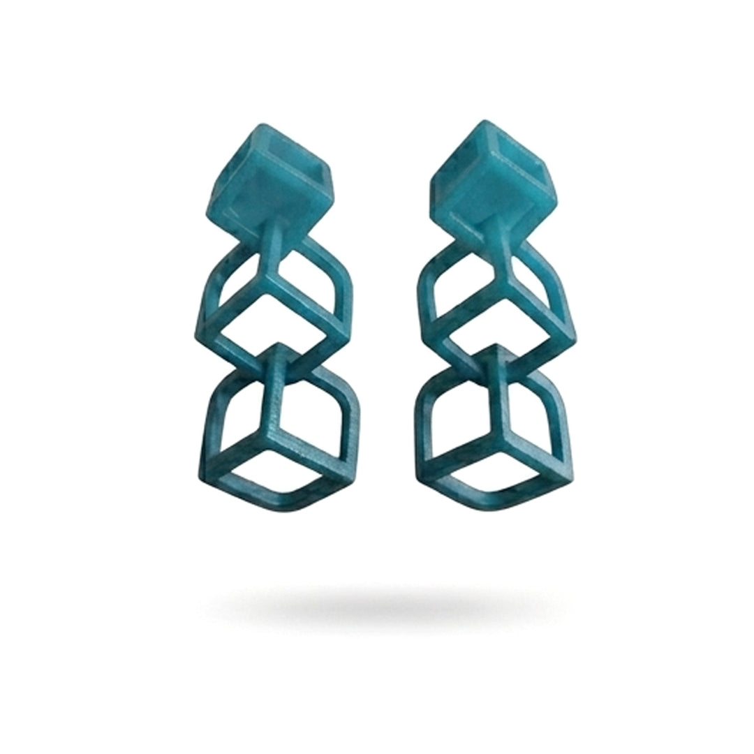 Tochu-De's Cubic Earrings Petrol feature three stacked open cubes in a geometric, vertical design with silver studs, set against a white background.