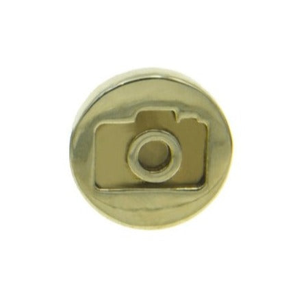 A round, gold-toned custom pin with an embossed design of a camera in the center. The Camera Lapel Pin by Millett Wade features a lens and a viewfinder, and it boasts a smooth, shiny surface.