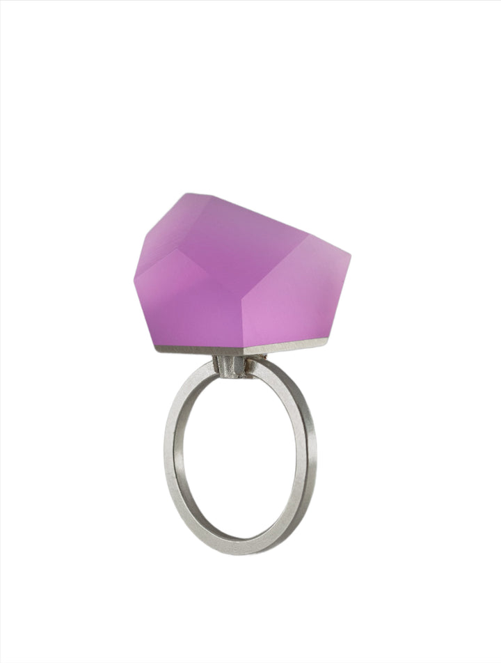 A Fruit Bijoux Fruit Bijoux Ring Top VU Crystals Carnation Pink with a large, faceted, geometric purple gemstone. The gemstone has an angular and modern design, creating a bold and contemporary look. The ring top features exquisite detailing, set against a plain white background.