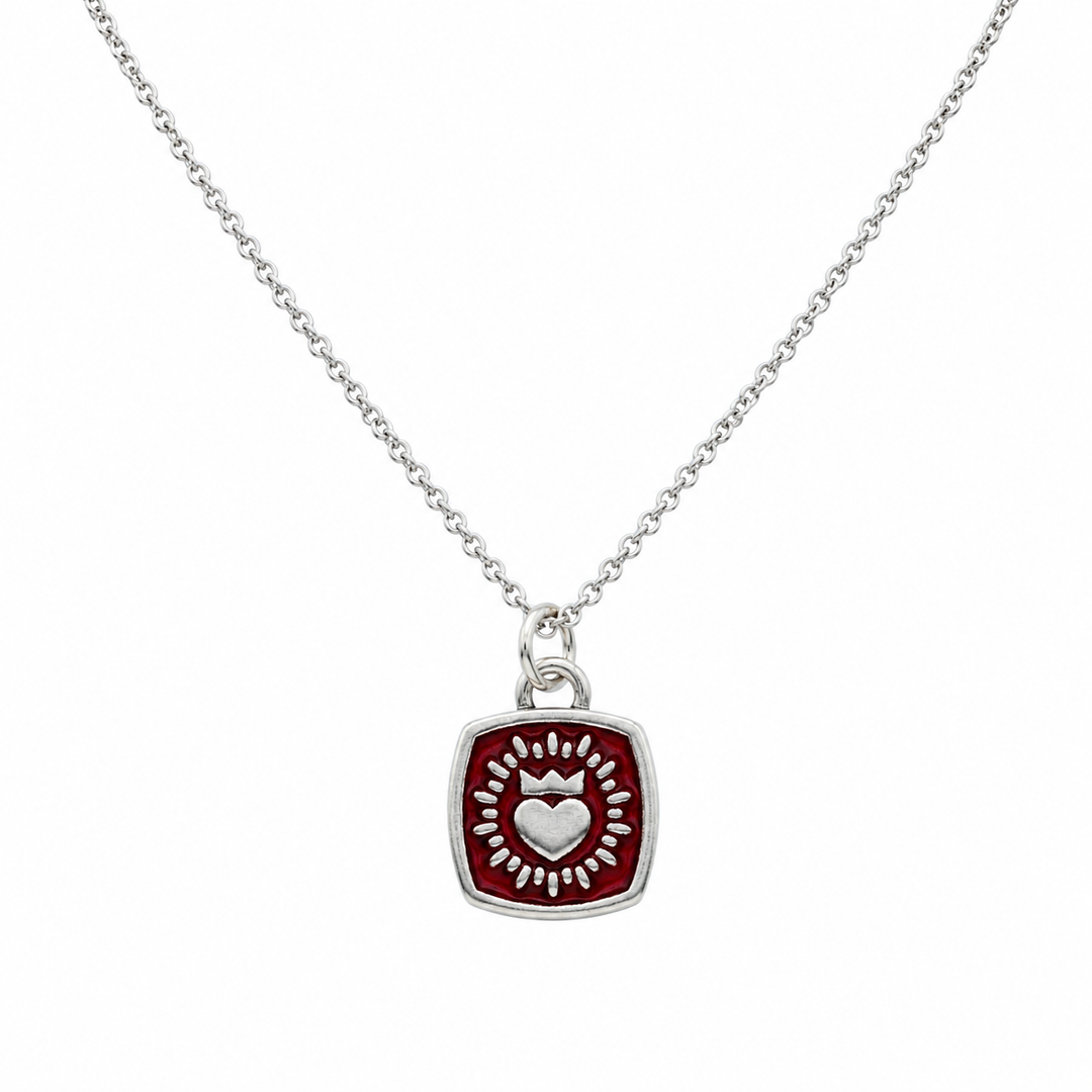 A Double Sided Keith Haring Pendant with Chain by The Collective Dublin, featuring a square pendant with a raised heart and radiating decorative pattern in silver at the center.