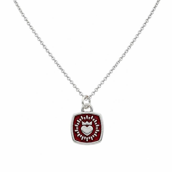 A Double Sided Keith Haring Pendant with Chain by The Collective Dublin, featuring a square pendant with a raised heart and radiating decorative pattern in silver at the center.