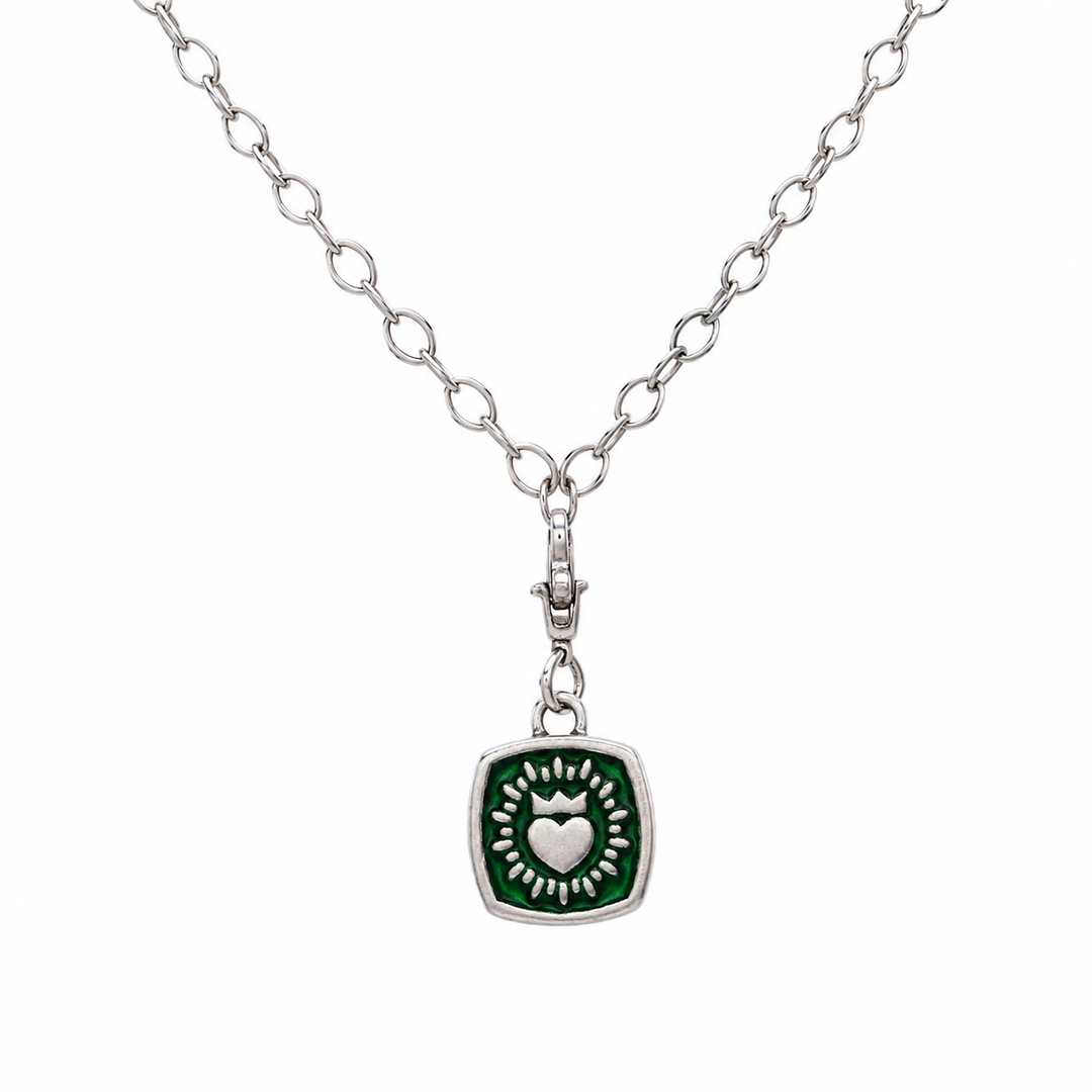 The Collective Dublin's Double Sided Keith Haring Pendant with Chunky Chain features a silver chain necklace adorned with a square green pendant, showcasing a raised heart encircled by a burst pattern. This distinctive Irish necklace subtly reflects Keith Haring-inspired artistry, making it an eye-catching addition to any jewelry collection for any occasion.