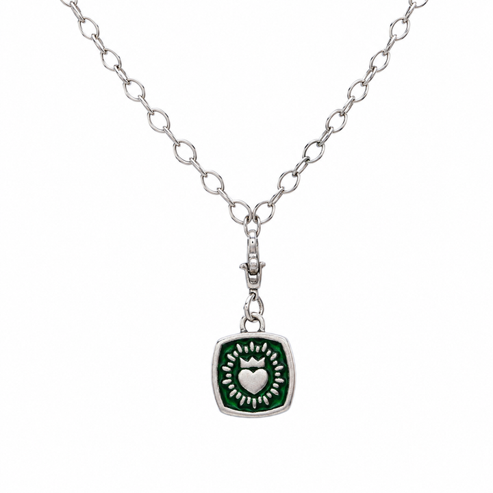 The Collective Dublin's Double Sided Keith Haring Pendant with Chunky Chain features a silver chain necklace adorned with a square green pendant, showcasing a raised heart encircled by a burst pattern. This distinctive Irish necklace subtly reflects Keith Haring-inspired artistry, making it an eye-catching addition to any jewelry collection for any occasion.