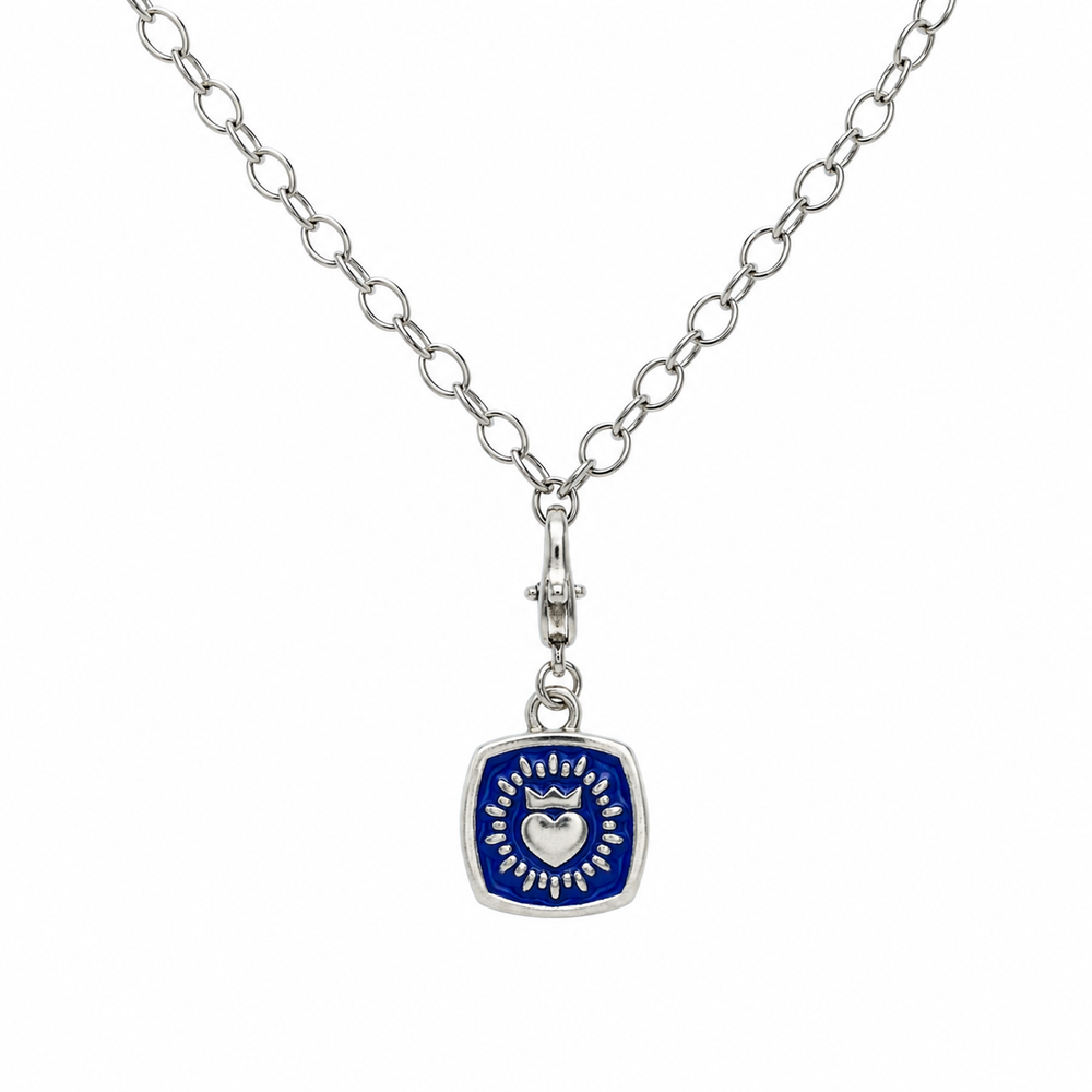 A double sided Keith Haring pendant with a chunky silver chain by The Collective Dublin, featuring a square blue centerpiece adorned with a heart and radiating lines, blending traditional Irish jewelry influences with modern design.