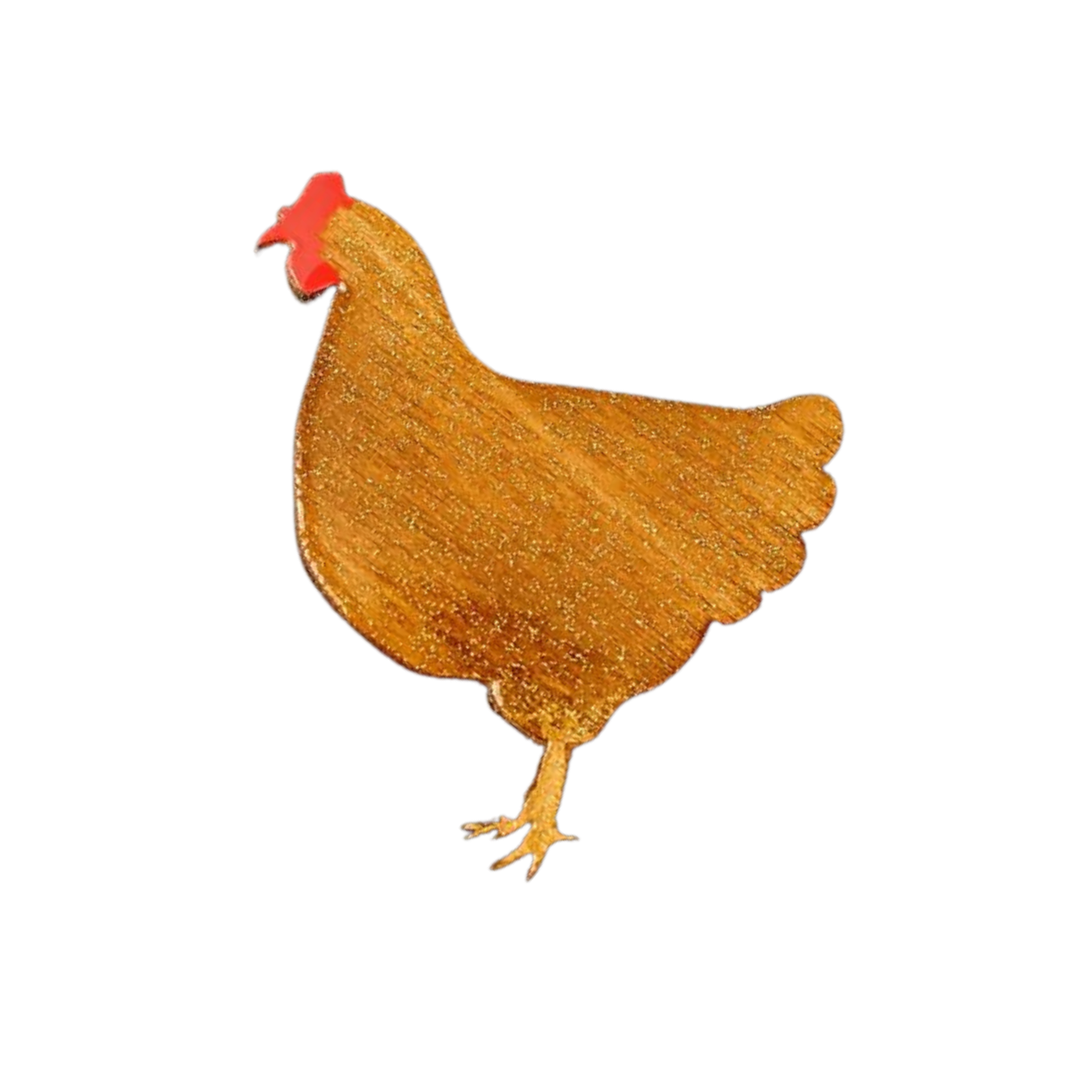 A stylized illustration of a chicken against a black background. The chicken, handpainted in a simple, solid golden color with a red comb on its head and a simplified body shape, exudes charm akin to handcrafted wooden chickens. The "Chicken Pin Brooch Gold" by Naoi captures this whimsical elegance perfectly.
