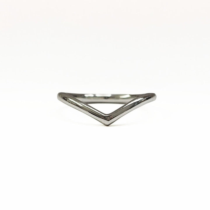 A minimalist silver ring with a pointy wishbone shape design, shown against a white background. Presenting the Wish Wedding Ring by The Collective Dublin.