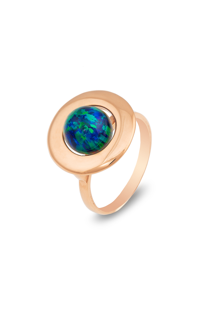 A Home Planet Night Sky Opal 9ct Gold ring by Cosmic Boulevard, featuring a circular Night Sky Opal gemstone set in a polished, round bezel setting. The ring has a smooth, shiny finish and a simple, elegant design. The opal displays a blend of blues and greens with hints of iridescent colors, reminiscent of the night sky.