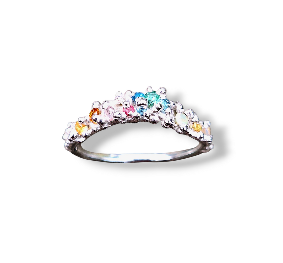 The Pale Raven Starborne Cosmic Wave Silver Stacking Ring features handcrafted jewelry with lab grown crystals in a vibrant, organic cluster design, creating a relic-like aesthetic against a white background.