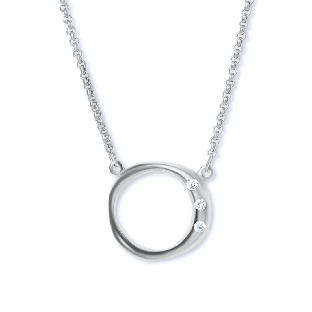 The Cualli Pendant & chain by Gallardo & Blaine Designs is a silver necklace with a circular pendant inspired by Spanish South American jewelry, featuring three round white gemstones set along one side.