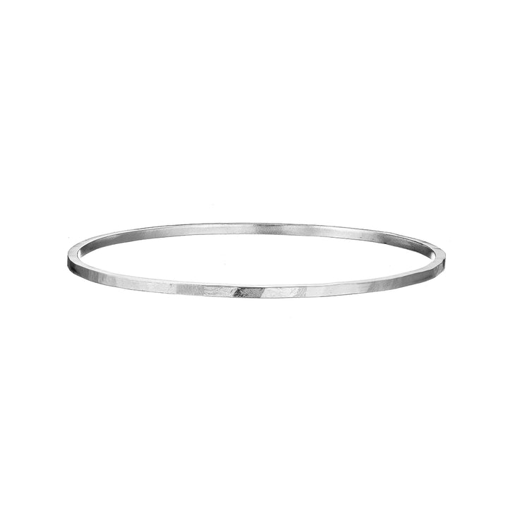 A sleek, minimalist sterling silver bangle bracelet with a thin, metallic band. The design is simple and elegant, featuring a smooth and polished surface that reflects light subtly. Hand-forged in Connemara, the Doon Bangle by Lynsey de Burca is shown on a plain white background.