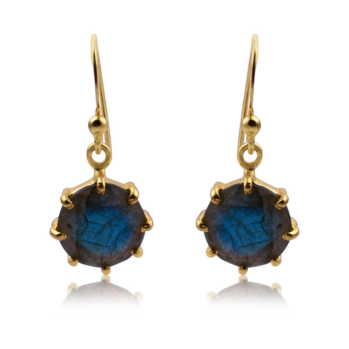 This image shows a pair of Labradorite Gold Dangles by Watermelon Tropical, featuring round, faceted blue gemstones held in gold prong settings. The stones have a marbled appearance and hang from delicate hooks. The handmade jewellery boasts a sophisticated and elegant design.