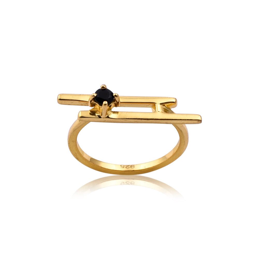 A Black Onyx Gold Bar Ring by Watermelon Tropical featuring a modern, abstract design with a small central Black Onyx gemstone. The band has a rectangular structure on top, creating a unique, geometric look. The handmade jewellery piece is isolated on a white background with a slight reflection beneath it.