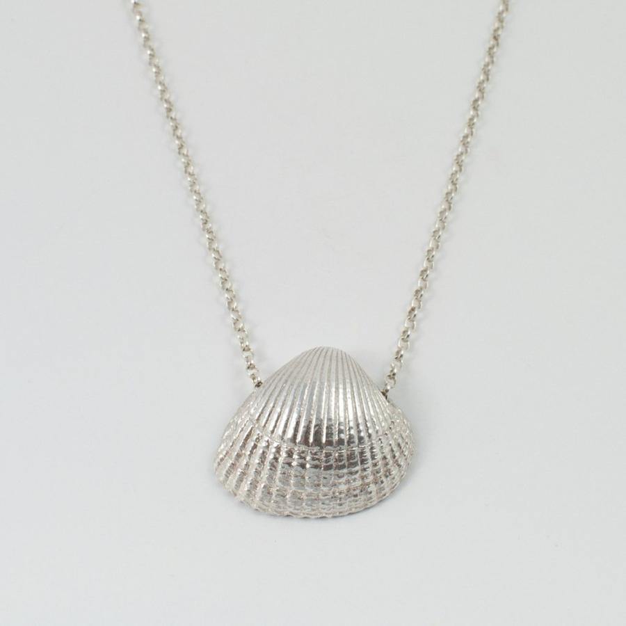 Introducing the Jennifer Kinnear Cockle Shell Necklace Large, available in both silver and gold. This exquisite piece showcases a beautifully detailed shell pendant on a delicate sterling silver chain, effortlessly blending elegance with chic simplicity. The plain white background accentuates the intricate texture of the shell charm, making it stand out brilliantly.