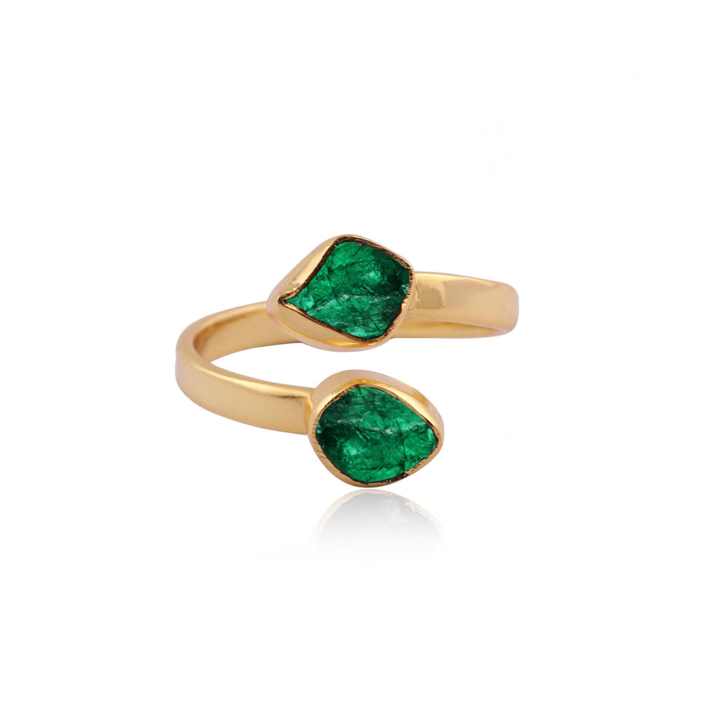 The Celia Gold Green Onyx Ring by Watermelon Tropical is a gold-plated ring that showcases two uniquely shaped rough-cut green onyx stones. The open-ended band arrangement positions the stones at opposite edges, crafting a visually striking accessory that harmonizes luxury with natural elegance against a plain white background.
