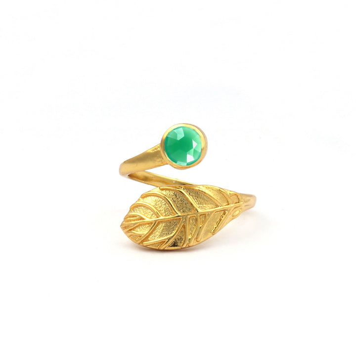 A Hannah Gold Ring in Chrysoprase by Watermelon Tropical with a leaf design featuring a Chrysoprase gemstone set in a bezel setting at one end. The ring's band is shaped to resemble a detailed leaf with textured veins. The overall design is elegant and nature-inspired.