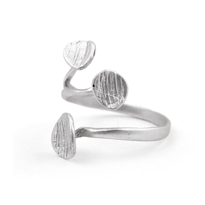 The Rachel Ring by Watermelon Tropical is a silver adjustable ring featuring an open design with two round, textured metal discs facing each other at the ends. The band, reminiscent of an Egyptian inspired ring, has a smooth finish and curves elegantly around the finger.