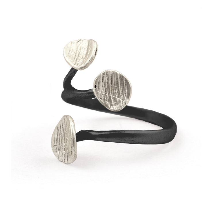 A modern and sleek black ring featuring a unique design with three silver, textured, oval-shaped embellishments. The ring's open and curvy structure adds an artistic, contemporary touch, embodying a triple disc design that is both stylish and sophisticated. This is the Rachel Ring by Watermelon Tropical.