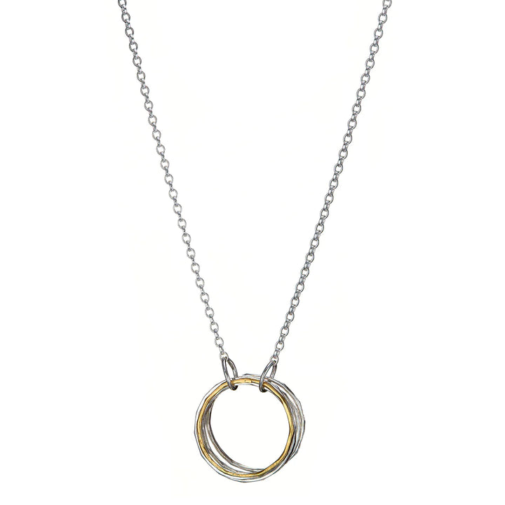 A delicate silver necklace featuring a hand-forged pendant of interlocking silver and yellow gold-plated rings — the Doorus Mix Pendant by Lynsey de Burca. The minimalist design is simple yet elegant, with the circular rings hanging from a fine Sterling silver chain.