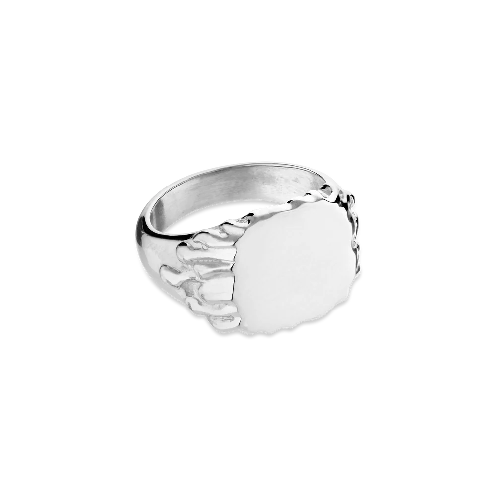 The Drippy Signet Ring by Jane Koenig is a sterling silver ring with a skeletal finger design gripping an oval face, shown on a white background.