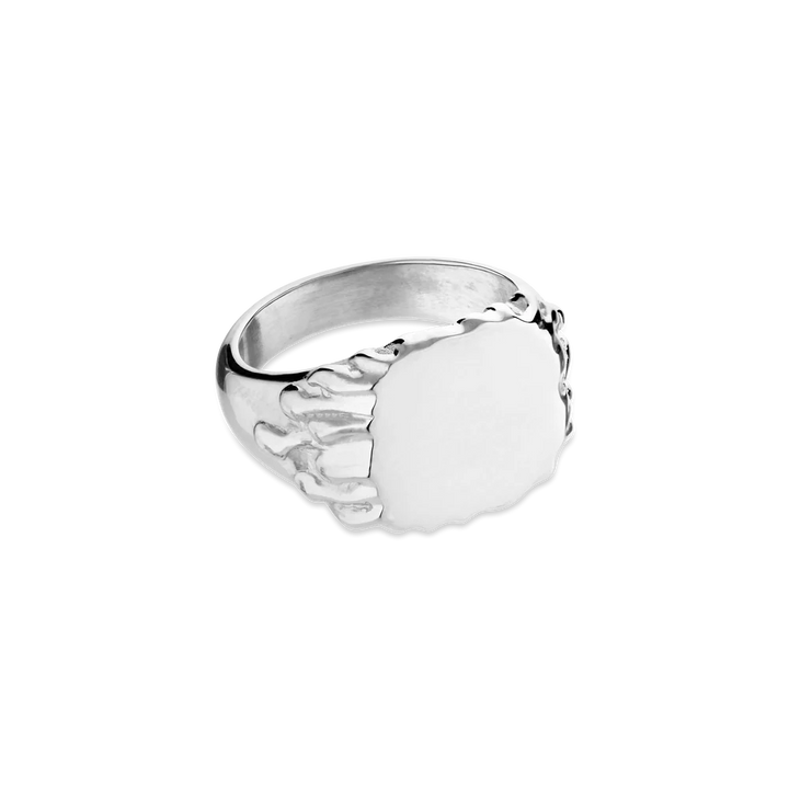 The Drippy Signet Ring by Jane Koenig is a sterling silver ring with a skeletal finger design gripping an oval face, shown on a white background.