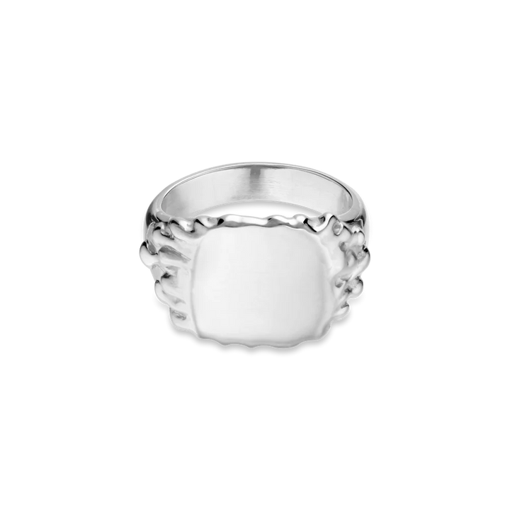 The Jane Koenig Drippy Signet Ring features a wide, polished sterling silver rectangular face with textured, organic-shaped edges, showcased on a plain white background—a modern update on the classic signet ring.