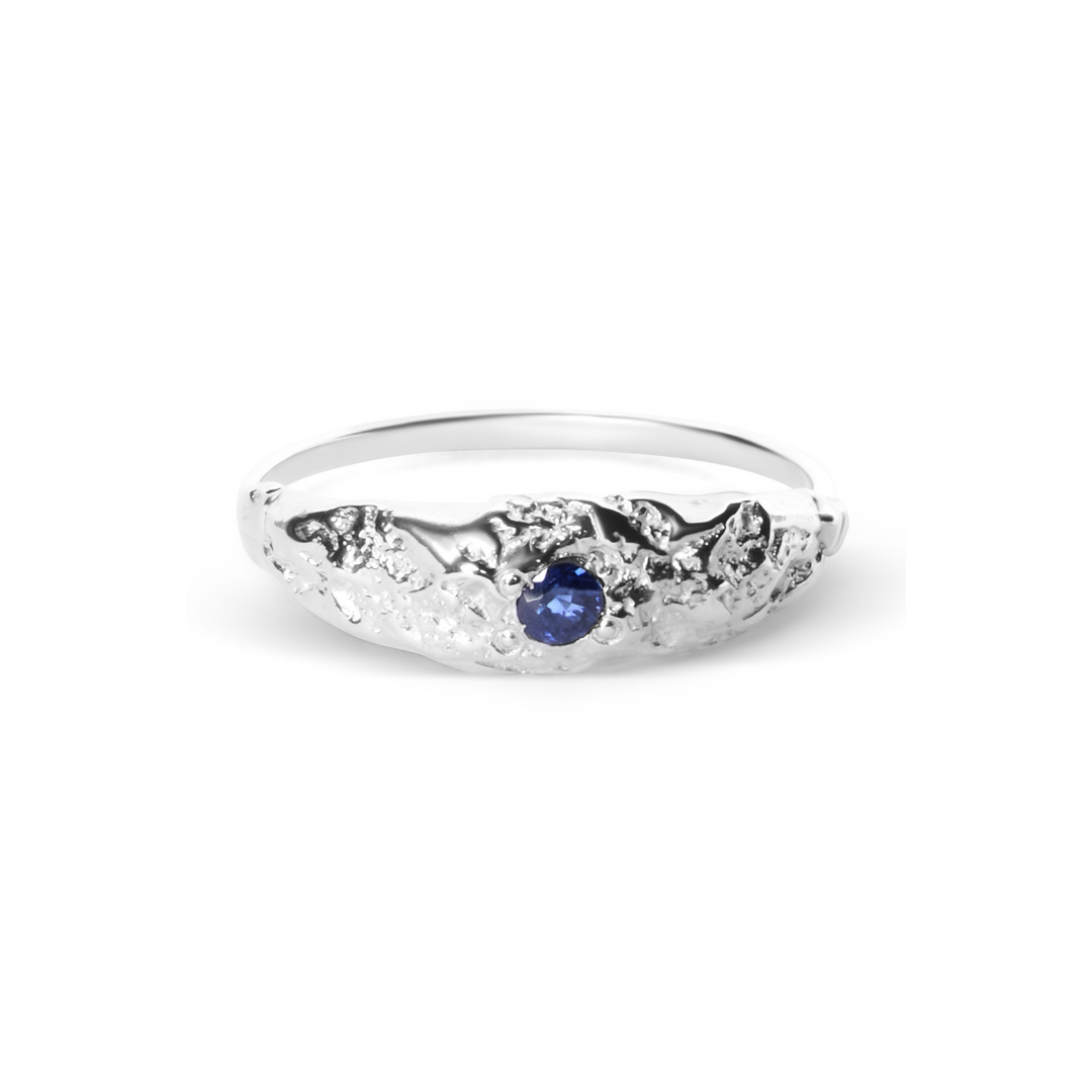 The Dublin Bay Silver Ring with Sapphire by Ava Jane Jewellery features a textured, organic sterling silver design with a central round blue sapphire.