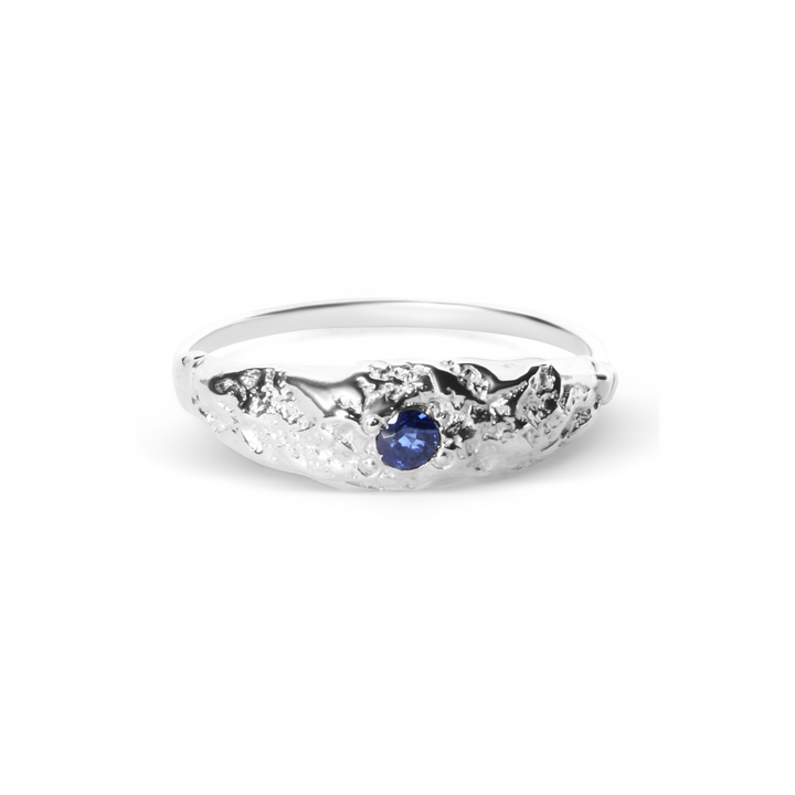 The Dublin Bay Silver Ring with Sapphire by Ava Jane Jewellery features a textured, organic sterling silver design with a central round blue sapphire.
