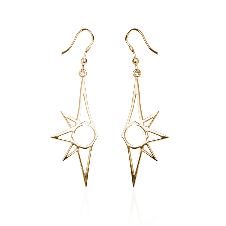 A pair of gold earrings featuring an abstract sunburst design, these Starlight Earrings by Cosmic Boulevard boast a central circular element with several pointed rays extending outward. The dangle-style earrings, hanging from delicate hooks, exhibit a minimalist and modern flair while evoking the charm of Starlight.