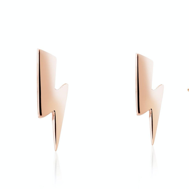 A pair of minimalist, rose gold lightning bolt-shaped earrings against a white background. The sleek design features sharp angles and a reflective surface, showcasing the fine craftsmanship of the Small Bowie Bolt Earrings 9ct Gold by Cosmic Boulevard.